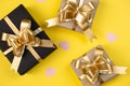 Holiday background. Various handmade gift boxes decorated with pink heart confetti on yellow background.