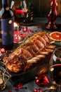 Holiday baked meat tenderloin with ribs, pork, roast beef on dark wooden board with glasses