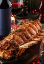 Holiday baked meat tenderloin with ribs, pork, roast beef on dark wooden board with glasses