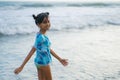 Beach lifestyle portrait of young beautiful and happy Asian child girl 8 or 9 years old with cute double buns hair style playing Royalty Free Stock Photo