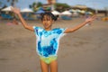 Beach lifestyle portrait of young beautiful and happy Asian child girl 8 or 9 years old with cute double buns hair style playing Royalty Free Stock Photo