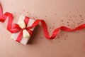 Holiday beige background with gift, red satin bow, ribbon. Valentine`s Day, Happy Women`s Day, Mother`s Day, Birthday, Wedding, Royalty Free Stock Photo