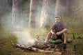 Holiday camp. Man traveler roast sausages on stick on campfire in forest Royalty Free Stock Photo