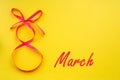 Holiday card with a pink ribbon in the form of a figure eight on a yellow background Royalty Free Stock Photo