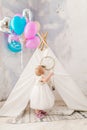 The holiday is the child`s birthday one year. A blonde girl in a dress is perpetually inside the interior in light colors and an Royalty Free Stock Photo