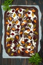 Holiday chocolate bark with dried fruits and nuts on a dark wood background. Top view. Dessert recipe for judaic holiday Tu Bishva