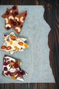 Holiday chocolate bark with dried fruits and nuts on a dark wood background. Top view. Dessert recipe for judaic holiday Tu Bishva