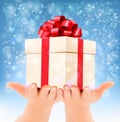Holiday christmas background with hands holding gift box. Royalty Free Stock Photo