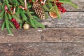 Holiday Christmas card with fir branches, Holly berries, dried oranges, etc. on rustic wooden background. Royalty Free Stock Photo