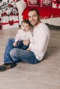 Handsome father playing with his small cute son near decorated New year tree Royalty Free Stock Photo