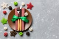 Holiday composition of Christmas dinner on cement background. Top view of plate, utensil and festive decorations. New Year Advent