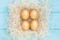 Holiday composition with four golden Easter eggs in square nest Royalty Free Stock Photo