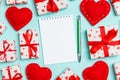 Holiday composition of notebook, gift boxes and red textile hearts on colorful background with empty space for your Royalty Free Stock Photo