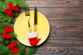 Holiday composition of plate and flatware decorated with Santa hat on wooden background. Top view of Christmas decorations with Royalty Free Stock Photo