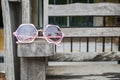 Cute pink women sunglasses on wooden bench