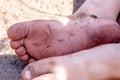 Holiday concept of dirty child feet on dirty soil Royalty Free Stock Photo