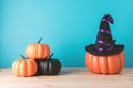 Holiday concept with Halloween pumpkin decor and witch hat on wooden table. Creative Halloween minimal concept