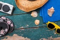 Holiday Concept: Vintage wood table with holiday accessories: Straw hat, sunglasses, flip flops, shells, vintage camera and bath