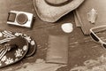 Holiday Concept: Vintage wood table with holiday accessories: Straw hat, sunglasses, flip flops, shells, vintage camera, towel and