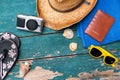 Holiday Concept: Vintage wood table with holiday accessories: Straw hat, sunglasses, flip flops, shells, vintage camera, towel and