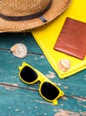 Holiday Concept: Vintage wood table with holiday accessories: Straw hat, sunglasses, shells, vintage camera and bath towel