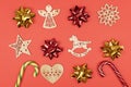 Holiday decorations. Composition made of red and gold bows, wooden Christmas tree toys, candy canes on red background. top view,