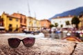 Holiday destination: Sunglasses on the ground, blurry Italian village in the background