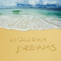 Holiday dreams written in a sandy beach