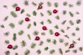 Holiday Festive Flat Lay Background with Small Green Branches Fir Tree and Red Christmas Balls on Pink Background Top View Royalty Free Stock Photo