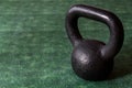Holiday fitness, black kettle bell on a multi-shade green background with white sparkles Royalty Free Stock Photo