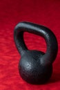 Holiday fitness, black kettle bell on a multi-shade red background Royalty Free Stock Photo