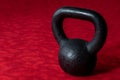 Holiday fitness, black kettle bell on a multi-shade red background Royalty Free Stock Photo