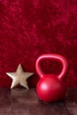 Holiday fitness, red kettlebell with big gold star, against a red background Royalty Free Stock Photo