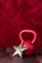 Holiday fitness, red kettlebell with big gold star, against a red background Royalty Free Stock Photo