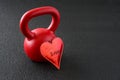 Holiday fitness, red kettlebell on a gym floor with a shiny red heart with love Royalty Free Stock Photo