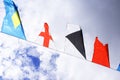 Holiday flags on a rope hanging, fluttering in the wind against the blue sky, holiday. Royalty Free Stock Photo