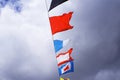 Holiday flags on a rope hanging, fluttering in the wind against the blue sky, holiday. Royalty Free Stock Photo