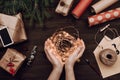 Holiday flatlay arrangement of wrapped presents and woman`s hands holding Christmas lights