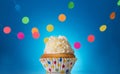 Holiday flavored cupcake on blue background with colorful garland