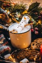 Holiday food white cup with hot chocolate cocoa snowman marshmallows. homemade sweet cookie, cinnamon stick fir xmas tree warm gar