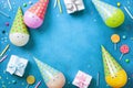 Holiday frame or background with funny balloons in caps, gifts, confetti, candy and candles. Flat lay. Birthday or party card. Royalty Free Stock Photo