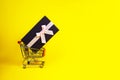 Holiday gift, Black Friday concept with gift box and pink bow in a metal shopping trolley, basket on yellow color Royalty Free Stock Photo