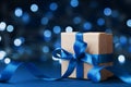 Holiday gift box or present with bow ribbon against blue bokeh background. Magic christmas greeting card.