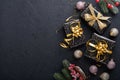 Holiday gift box or present with ribbon, golden confetti and gold baubles on black background. Magic christmas greeting card. Chri Royalty Free Stock Photo