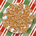 Holiday gingerbread man cookies in plate on colored Christmas gingham tablecloth