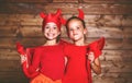 holiday halloween. funny funny sisters twins children in carnival costumes devil on wooden Royalty Free Stock Photo