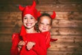 holiday halloween. funny funny sisters twins children in carnival costumes devil on wooden Royalty Free Stock Photo