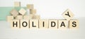 Holiday at home concept. Hand turns a cube Royalty Free Stock Photo