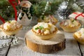 Holiday hors d`oeuvre: tartlets with crab sticks, cheese and pineapple on a celebratory Christmas background