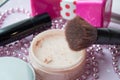 friable powder and brush, lipstick on a pink texture background